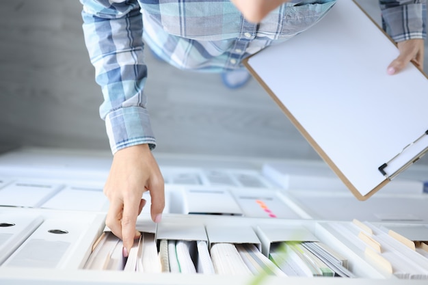 Woman takes out business documents from cabinet closeup