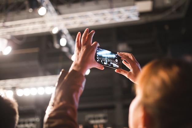 a woman takes a picture with her cell phone.