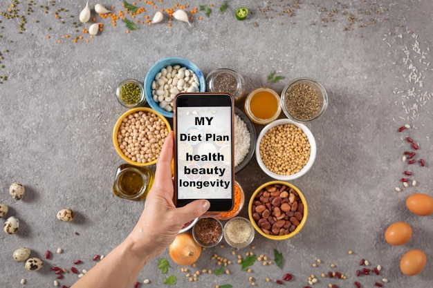 Woman takes pictures on a smartphone and has a slogan on the screen My diet plan is health beauty