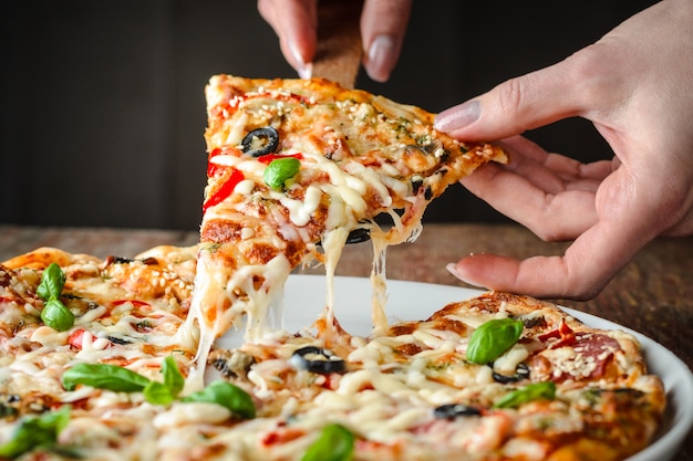 Woman takes a piece of pizza