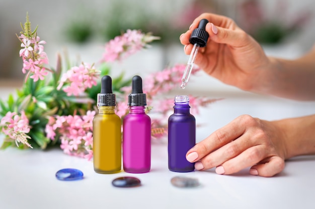 woman takes a sampler of liquid from a jar