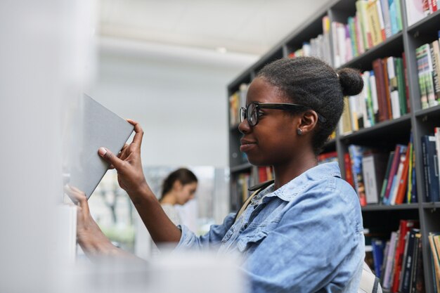 図書館で本を取る女性