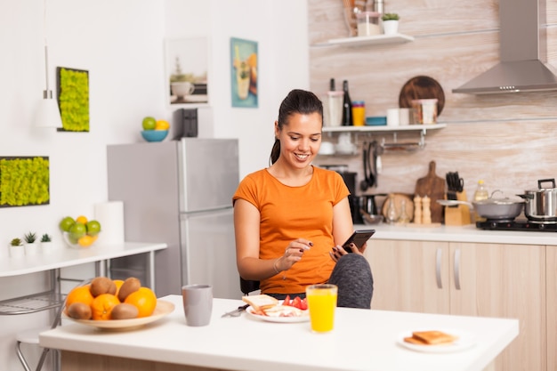 Woman taking the breakfast alone in modern kitchen