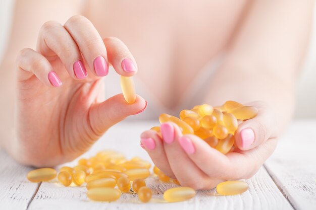 Photo woman taking capsule with cod liver oil