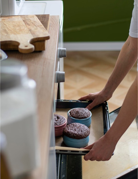 Woman taking chocolate mugcake out of microwave oven closeup Vertical image