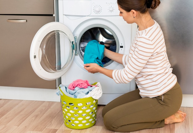 Photo woman taking clothes out washing machine