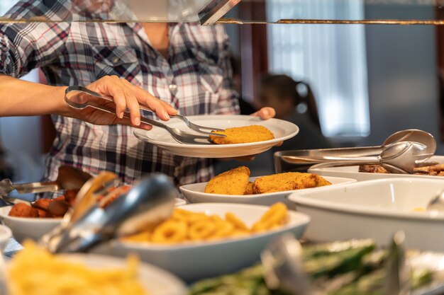 セルフサービスから食べ物を取る女性