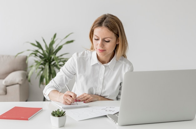 woman taking notes at an online class