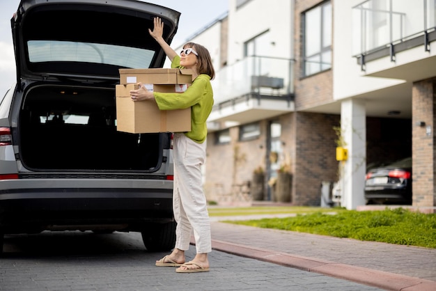 Woman taking parcels from a car trunk