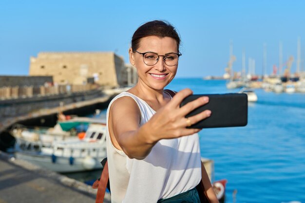 歴史的な要塞海湾を背景に写真を撮る女性