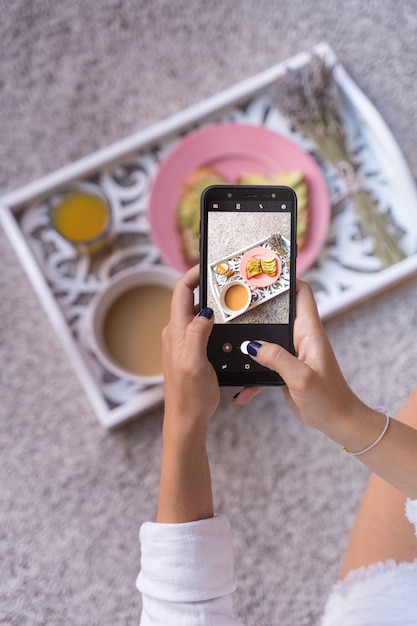 Photo woman taking photo of breakfast