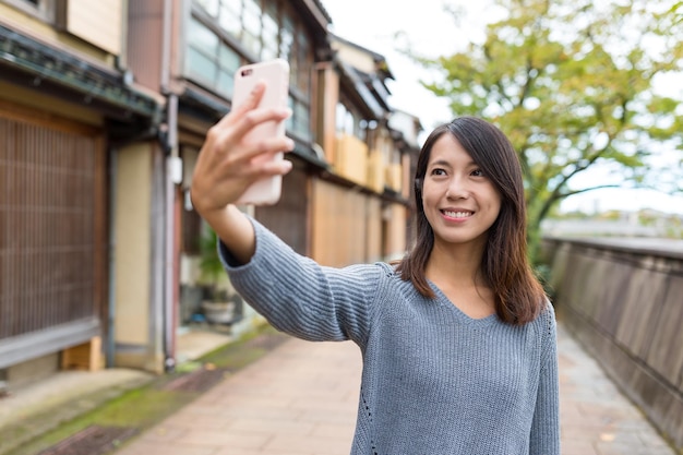 Woman taking photo by mobile phone in Kanazawa