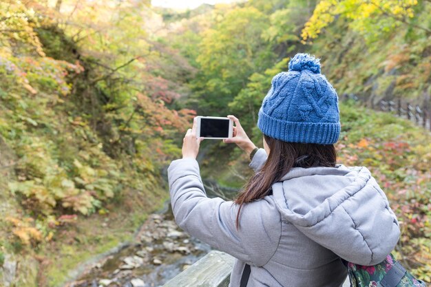 Woman taking photo in forest