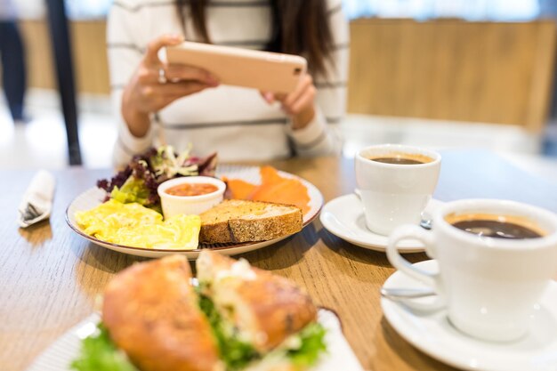 Photo woman taking photo on her dish