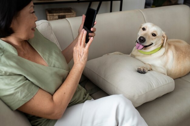 Photo woman taking a photo of her dog