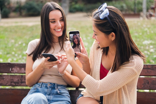 Woman taking a photo of her friend with a phone