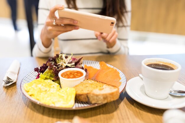 Photo woman taking photo on her meal