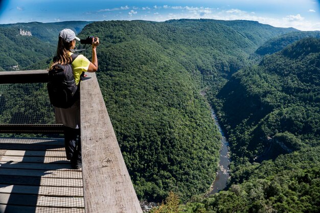 Photo woman taking a photo of a misty valley in the mountains