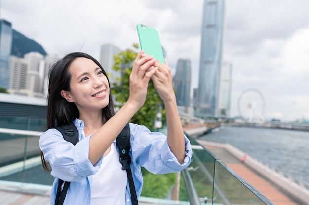 Woman taking photo on mobile phone in Hong Kong