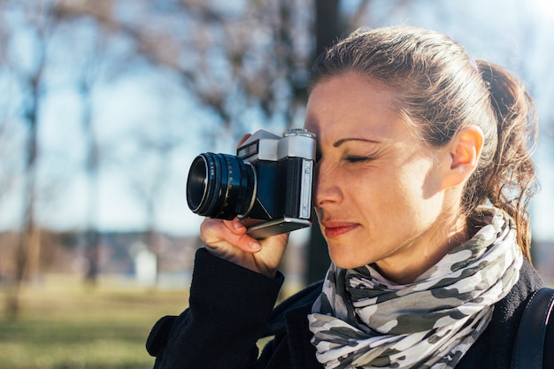 Woman taking a photo with analog camera