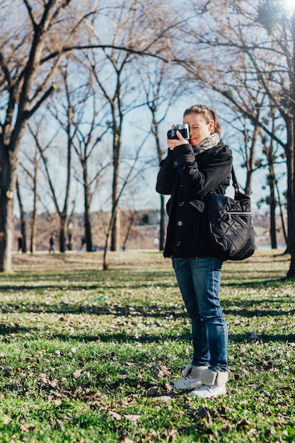 Woman taking a photo with old analog camera