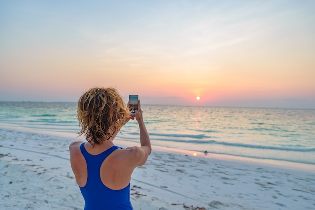 女性がスマートフォンで写真を撮る