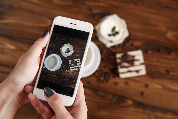 Woman taking photograph of snacks with her smartphone