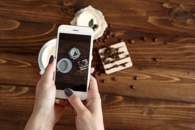 Woman taking photograph of snacks with her smartphone