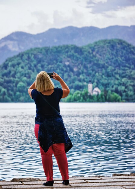 Woman taking photos of Bled Lake, Slovenia