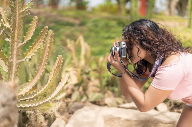 Woman taking photos with a camera in a park