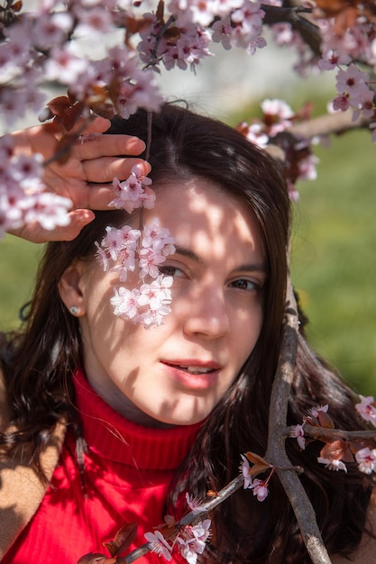 花をかせている桜の木で写真を撮っている女性