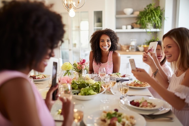 Photo woman taking picture of her friends at dinner party
