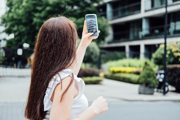 Woman taking picture of the new house with mobile phone homebuyer using smartphone to photograph the