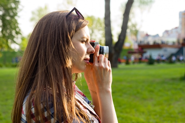 Woman taking pictures on the camera at sunset