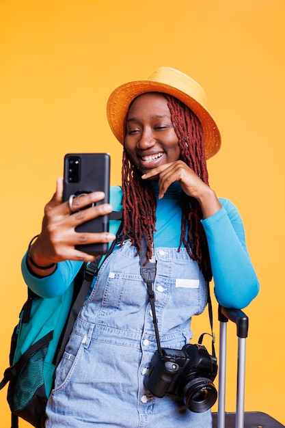 Woman taking pictures on mobile phone, having fun with photos on international holiday destination. Female tourist taking photographs with smartphone, acting funky on vacation trip.