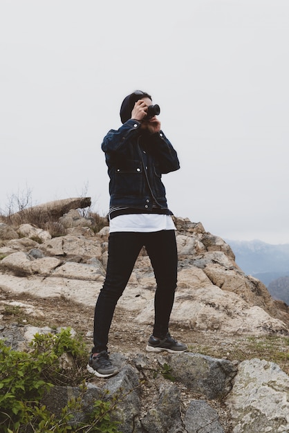 The woman taking pictures at the top of the mountain