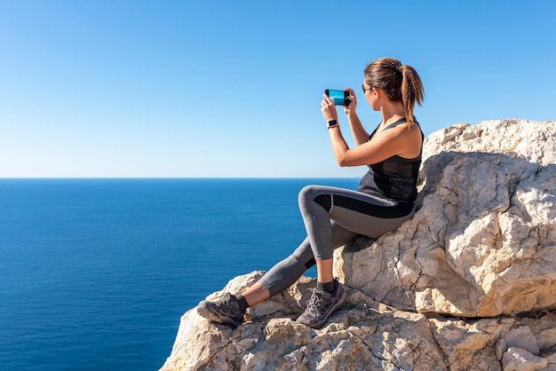 カルペのペニョンデイファクから自然の中で、スマートフォンで風景に写真を撮る女性