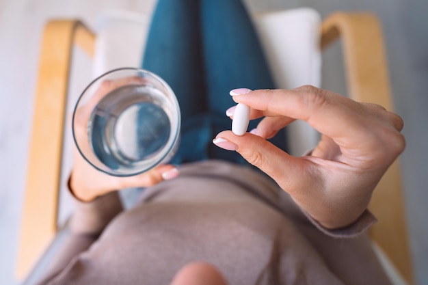 Woman taking pill medicine antidepressant or antibiotic Painkiller from headache or stomach pain