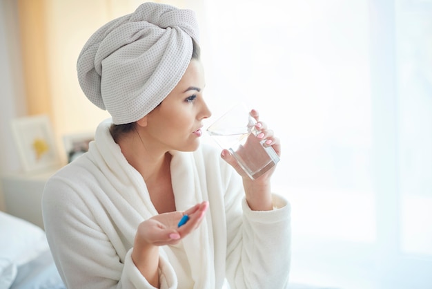 Woman taking pill at the morning