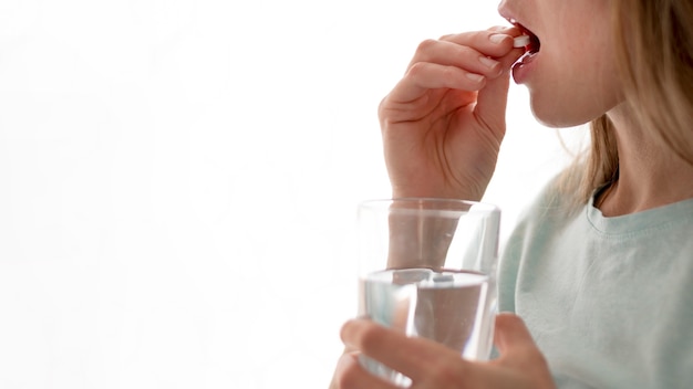 Woman taking pills copy space