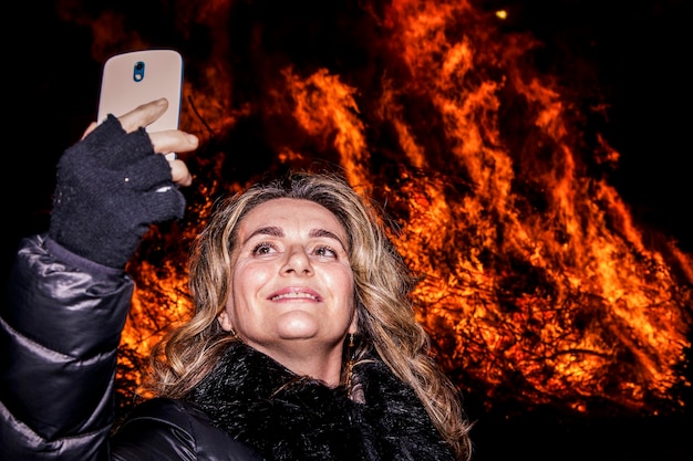  Premium Photo | Woman taking selfie against bonfire at night