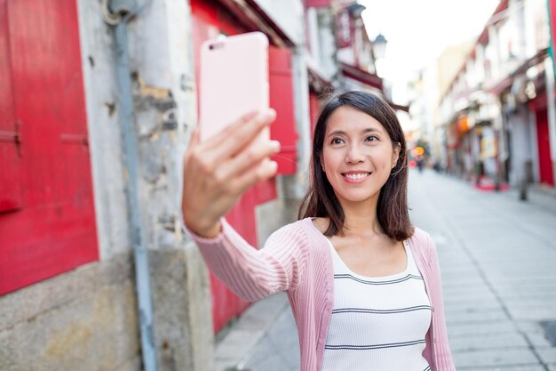 Женщина делает селфи по мобильному телефону в городе Макао