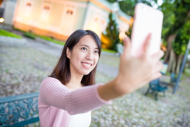 Женщина делает селфи по мобильному телефону в Museu da Taipa