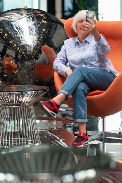 Woman taking a selfie in front of a silver metallic ball