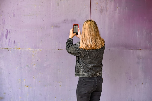 Foto donna che cattura selfie su uno sfondo grunge. nuovo concetto di stile di vita normale