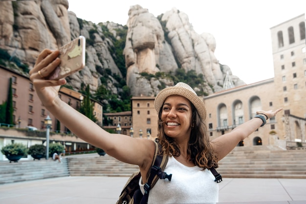 Foto donna che cattura una foto selfie nel monastero di montserrat, barcellona, spagna