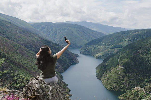 Woman taking selfie with the river