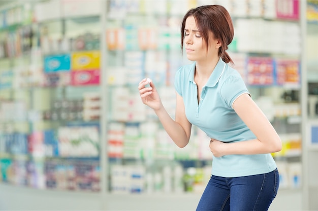 Woman taking a tablet. Close up hand with a pill and the mouth, isolated on background