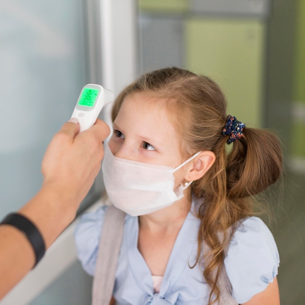 Donna che misura la temperatura di una ragazza