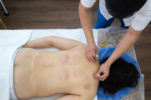 Photo a woman taking a treatment of alternative medicine in clinic moxo therapy procedure